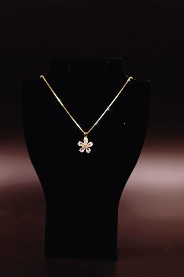 colar dourado com pingente de flor cravejado